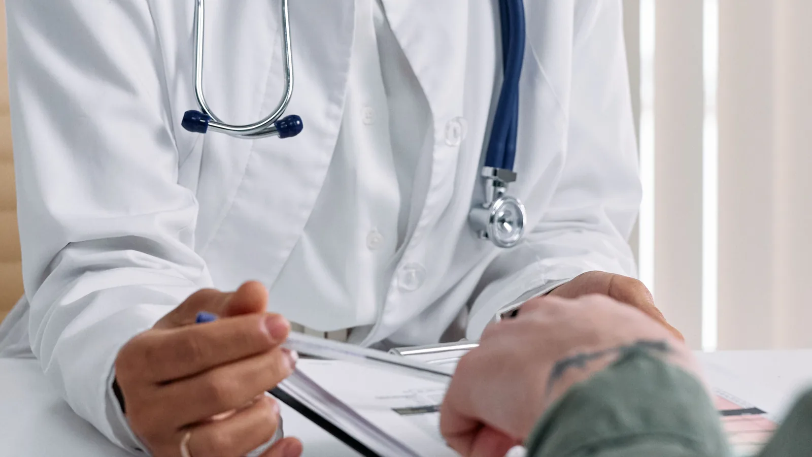 Healthcare professional and another adult reviewing a form during a consultation